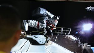 Ein Mann verfolgt vor dem Fernseher die Live-Übertragung eines Außeneinsatzes an der Raumstation Tiangong (Archivbild). Foto: Sheldon cooper/SOPA Images via ZUMA Wire/dpa